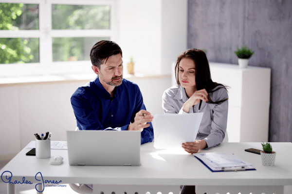 Business professionals reviewing documents together at a desk.